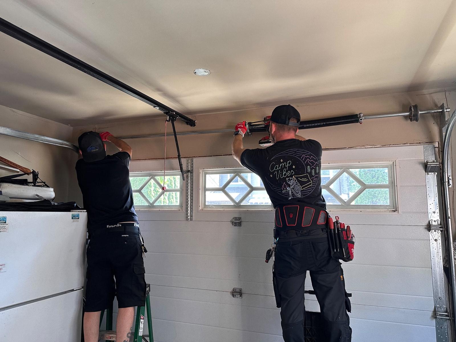 Burrard Doors technicians repairing a garage door